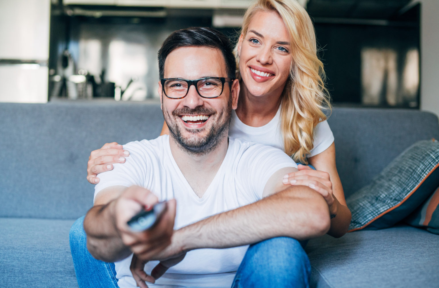 Cute young couple cuddling while watching tv. MrOwl Blog